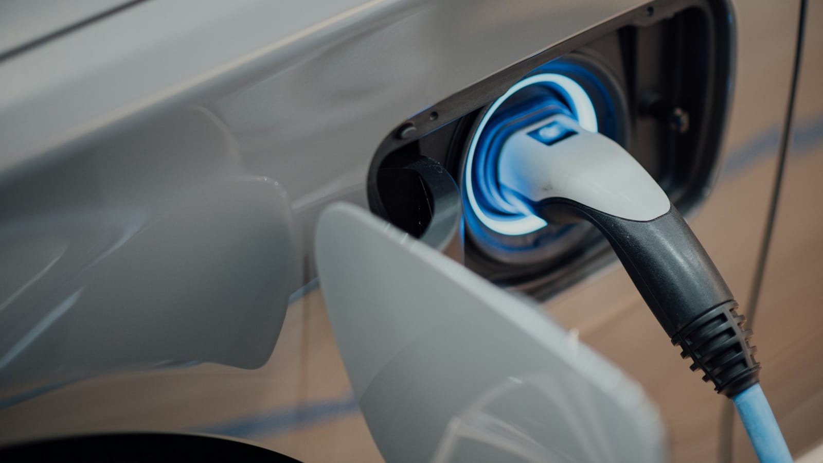 A charging cable connected to an electrified car's charge port